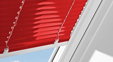 Dachfensterjalousie in rot und weißen Schienen