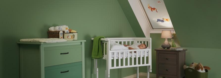 Baby in Wiege unter Winnie Puuh Rollo